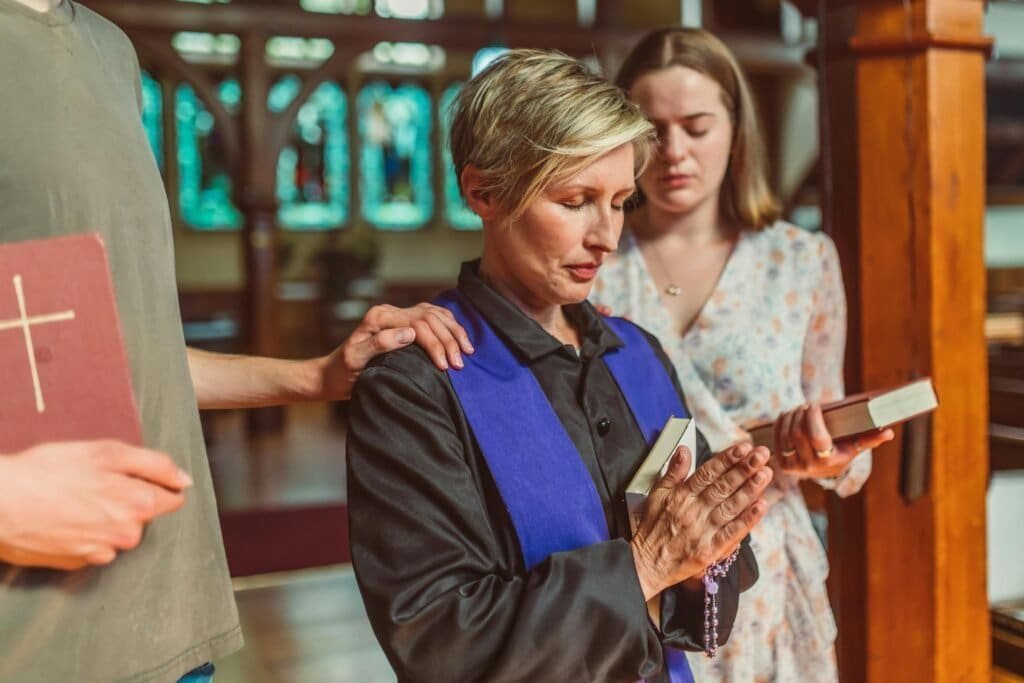 What Is Christianity? 7 Blonde woman praying at church with friends