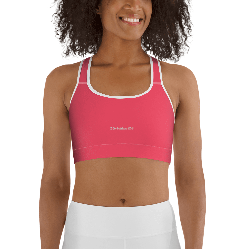 Smiling-woman-wearing-a-pink-sports-bra-that-says-2-Corinthians-12:9-in-white-letters