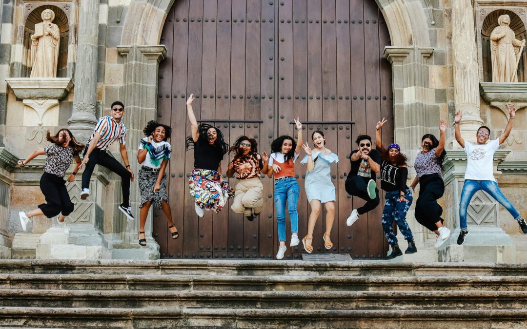 Large-Group-of-Young-Adults-Jumping-for-Joy-in-front-of-a-large-Catholic-church-Doorstep