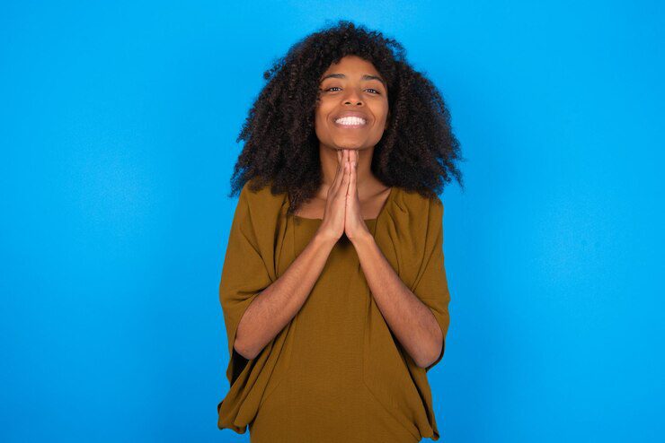 woman-praying-with-hands-together-thankful-to-Jesus-smiling-confident